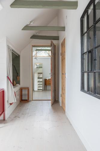 an open door to a room with white walls and white floors at Villa Verde Österlen in Glemminge
