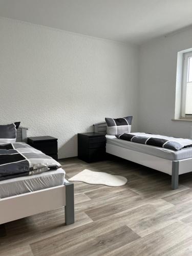 Duas camas num quarto com pisos em madeira em F&M Wohnungen in Olpe em Olpe