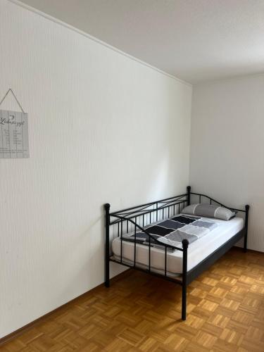 1 dormitorio con 1 cama contra una pared blanca en F&M Wohnungen in Olpe, en Olpe