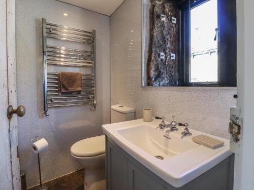 ein Bad mit einem Waschbecken, einem WC und einem Fenster in der Unterkunft Weaver's View in Hebden Bridge