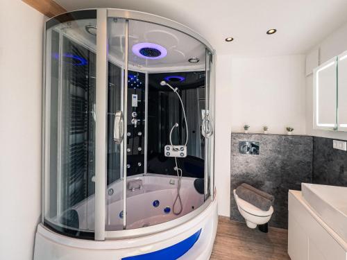 a glass shower in a bathroom with a toilet at CREST - Riverside Lofts mit Whirlpool & Wanne I Parken I Balkon I Netflix I Küche in Passau