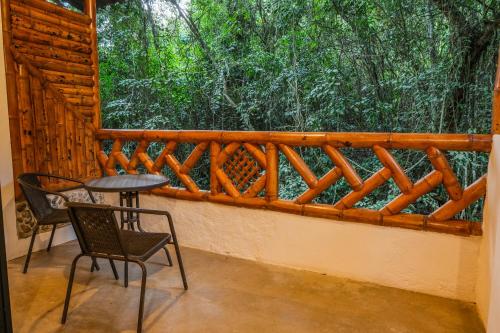 d'un balcon avec une table, des chaises et une clôture. dans l'établissement Huitaca Ecohotel, à Hispania