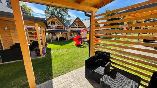 a wooden pergola with a bench in a yard at Ośrodek Wypoczynkowy Złote Piaski in Jarosławiec