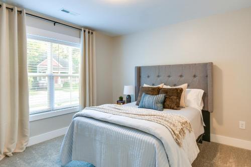 a bedroom with a bed with a large window at Cozy South Carolina Abode - Steps from Main Street in Greenville