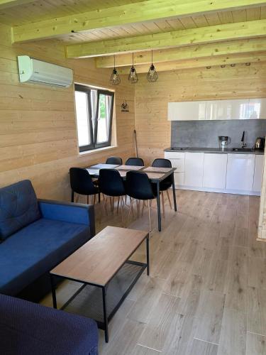 a living room with tables and chairs and a kitchen at Ośrodek Wypoczynkowy Złote Piaski in Jarosławiec