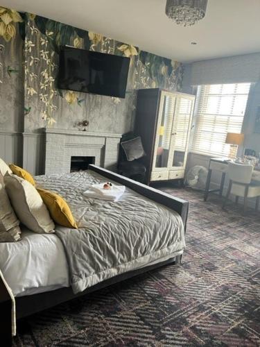 1 dormitorio con 1 cama y chimenea en The New Boar, en Theydon Bois
