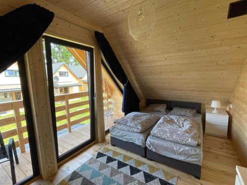 a small bedroom with two beds and a balcony at Ośrodek Wypoczynkowy Złote Piaski in Jarosławiec