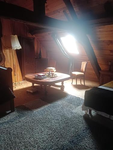 a room with a table and a lamp in a attic at Marie-Claire la grillade in Briare