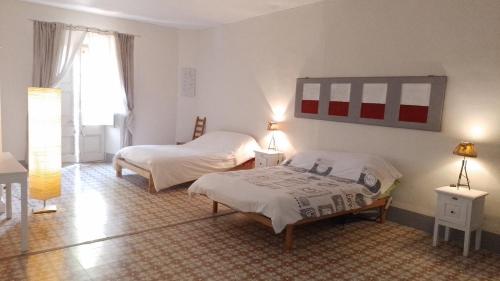 a bedroom with two beds and two lamps and a window at Casa rural El refugi platja d'aro in Romanyá de la Selva
