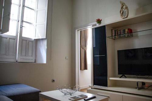 uma sala de estar com uma televisão de ecrã plano e uma janela em Apartamento Spinola Home em Sevilha