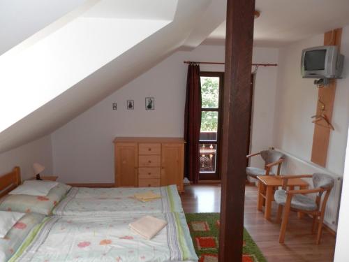 - une chambre avec un lit, une table et une fenêtre dans l'établissement Penzion Stárek, à Terchová