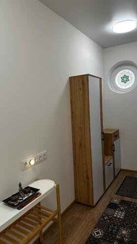 a room with a table and a wooden cabinet at Japandi apartamentai in Kaunas