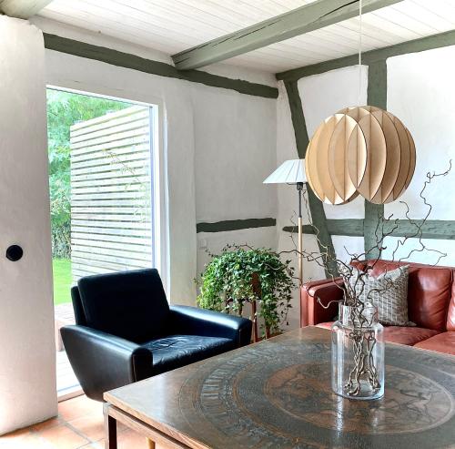 a living room with a table and a chair at Villa Verde Österlen in Glemminge