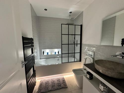 a bathroom with a sink and a toilet and a tub at A super luxury large apartment in Barnet