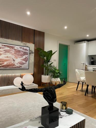 a living room with a statue on a table at Cosy bedroom in Luxury apartment in London