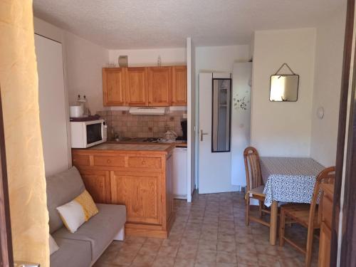 a kitchen with a couch and a table with a microwave at Appartement avec piscine in Cavalaire-sur-Mer