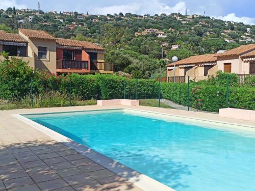 a swimming pool in front of a house at Appartement avec piscine in Cavalaire-sur-Mer