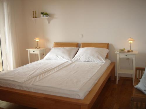 een slaapkamer met een bed met 2 nachtkastjes en 2 lampen bij Villa Delina in Rab