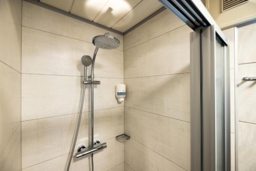 a shower with a shower head in a bathroom at Sportpension Bergblick in Wagrain