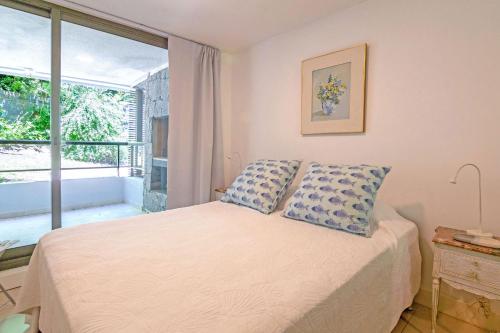 1 dormitorio con cama y ventana grande en Oceana Suites en Unique, piscina climatizada, en Punta del Este