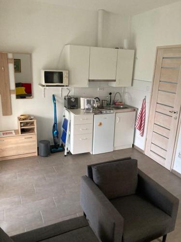 een woonkamer met een bank en een keuken bij FÜGÉSKERT in Balatonfüred