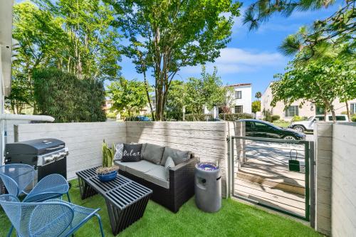 un patio trasero con una valla, un sofá y una parrilla en Beverly Grove Chic City Oasis 2 BR Apt with Den 138 en Los Ángeles