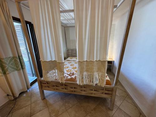 Habitación con cama con cortinas y ventana en Villetta Calasetta intera casa vacanze, en Calasetta