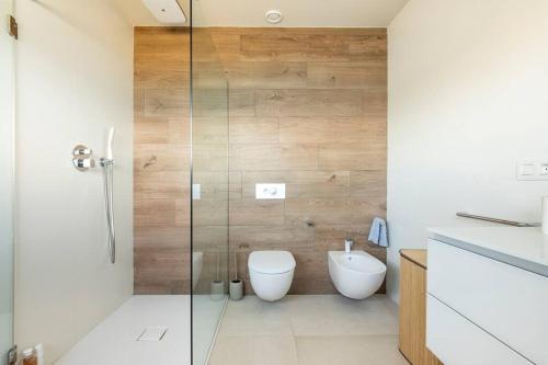 a bathroom with a toilet and a glass shower at Suite en el Faro de Hondarribia, con vistas in Hondarribia