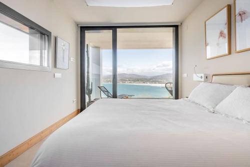 a bedroom with a large bed with a view of the ocean at Suite en el Faro de Hondarribia, con vistas in Hondarribia