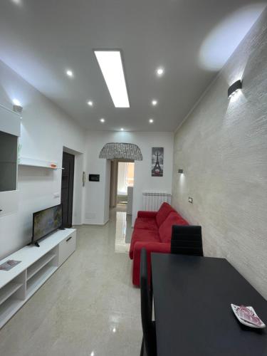 ein Wohnzimmer mit einem roten Sofa und einem TV in der Unterkunft Casa vacanza l’archetto in Genzano di Roma
