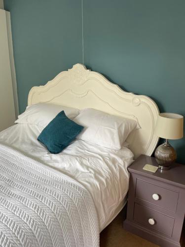 - une chambre avec un lit blanc et un mur bleu dans l'établissement Heart of Cockermouth Gem 4 bedrooms 6 beds 2 bathrooms, à Cockermouth