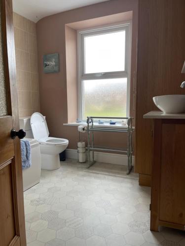 La salle de bains est pourvue de toilettes, d'un lavabo et d'une fenêtre. dans l'établissement Heart of Cockermouth Gem 4 bedrooms 6 beds 2 bathrooms, à Cockermouth