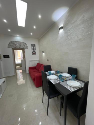 a living room with a table and a red couch at Casa vacanza l’archetto in Genzano di Roma