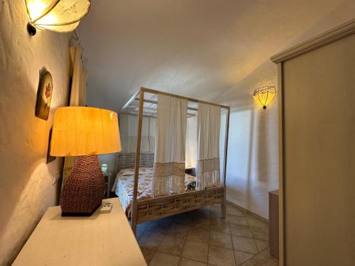 ein Schlafzimmer mit einem Bett und einer Lampe auf einem Tisch in der Unterkunft Villetta Calasetta intera casa vacanze in Calasetta