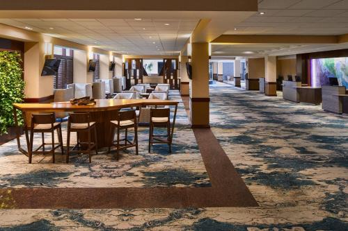 a hallway with tables and chairs in a lobby at The Westin San Francisco Airport in Millbrae