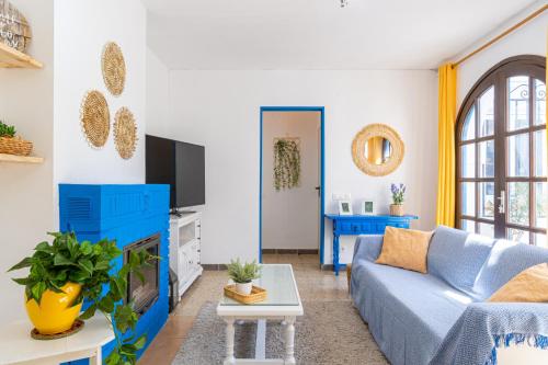 a living room with a blue couch and a tv at Cambrils Beach - 8 min to Beach - AC - WiFi - Terrace - 8 Guests in Cambrils