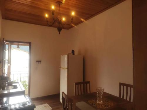 een keuken met een tafel en een witte koelkast bij Apartamento Bela Vista in Tiradentes