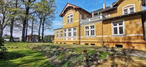 a large brick building with a yard in front of it at FamilyandBike in Neupetershain
