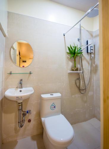 a bathroom with a toilet and a sink and a mirror at ALONA BEACH SIDE INN in Panglao