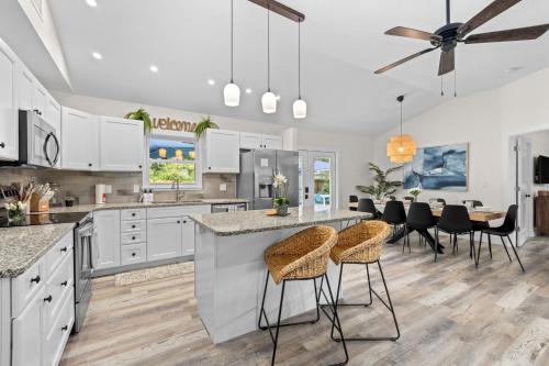 a kitchen with white cabinets and a bar with stools at Heated Salt Pool, Arcade, 2 Kings, Near Ami, Img in Bradenton