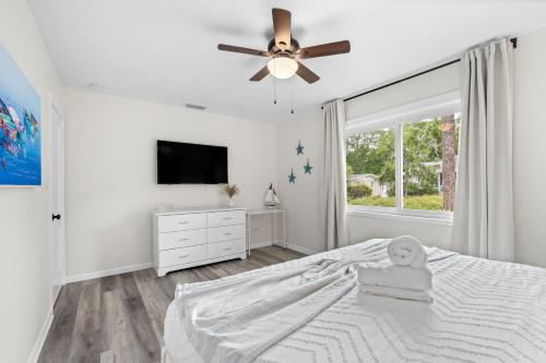 a white bedroom with a bed and a tv at Heated Salt Pool, Arcade, 2 Kings, Near Ami, Img in Bradenton