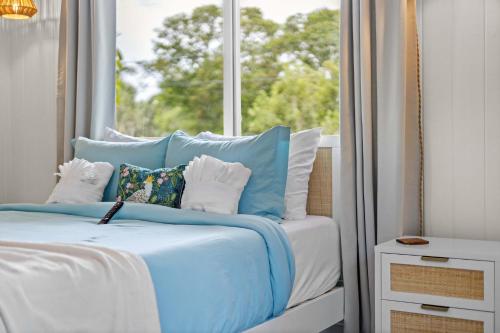 a bed with blue and white pillows and a window at Heated Salt Pool, Arcade, 2 Kings, Near Ami, Img in Bradenton