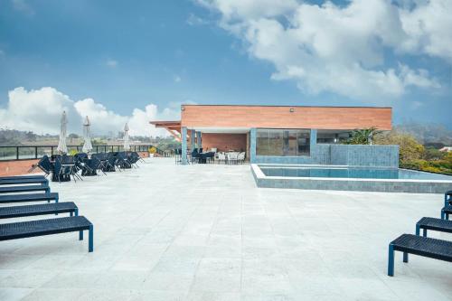 a patio with chairs and a building with a pool at Hotel Titanic Penedo in Penedo