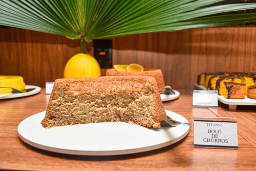 a piece of cake on a plate on a table at Hotel Titanic Penedo in Penedo