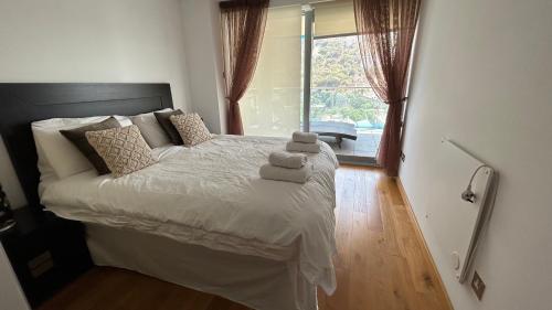 een slaapkamer met een bed met twee handdoeken erop bij Ocean Village Luxury 2 Bed 2 Bath Apartment - amazing views - pools and jacuzzis in Gibraltar