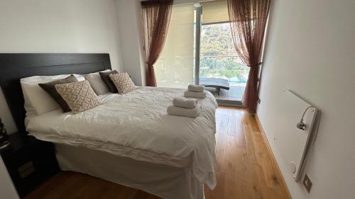 ジブラルタルにあるOcean Village Luxury 2 Bed 2 Bath Apartment - amazing views - pools and jacuzzisのベッドとタオル2枚のある寝室