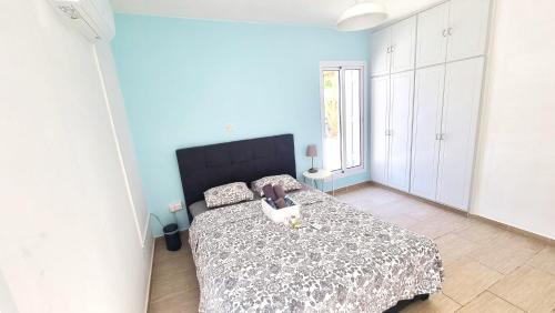 - une chambre avec un lit à tête noire dans l'établissement Dream Escape Apt 1 - 6 min walk to Kastella Beach!, à Larnaka