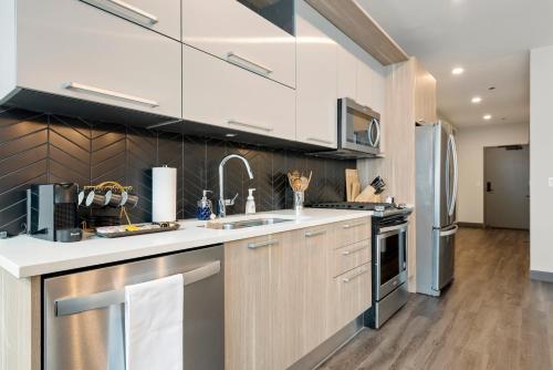 a kitchen with white cabinets and stainless steel appliances at Experience Downtown Chicago at Millennium - Luxury Apartments in The Loop in Chicago