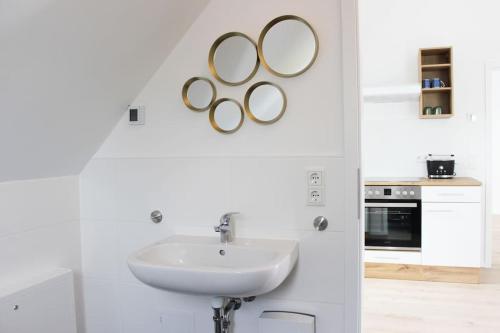a white bathroom with a sink and two rings on the wall at Beautiful terrace apartment in Bad Soden in Bad Soden am Taunus