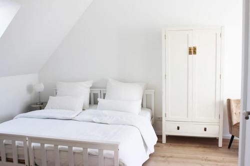a white bedroom with two beds with white pillows at Beautiful terrace apartment in Bad Soden in Bad Soden am Taunus